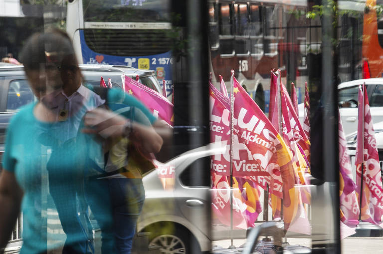 Bandeiras da campanha do Lula e Haddad na esquina da rua Carlos Sampaio com avenida Paulista vistas através do vidro da estação Brigadeiro do metrô