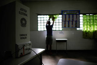 An electoral worker installs electronic voting machines that will be used in the runoff of the upcoming Brazilian presidential elections, at a voting station in Brasilia