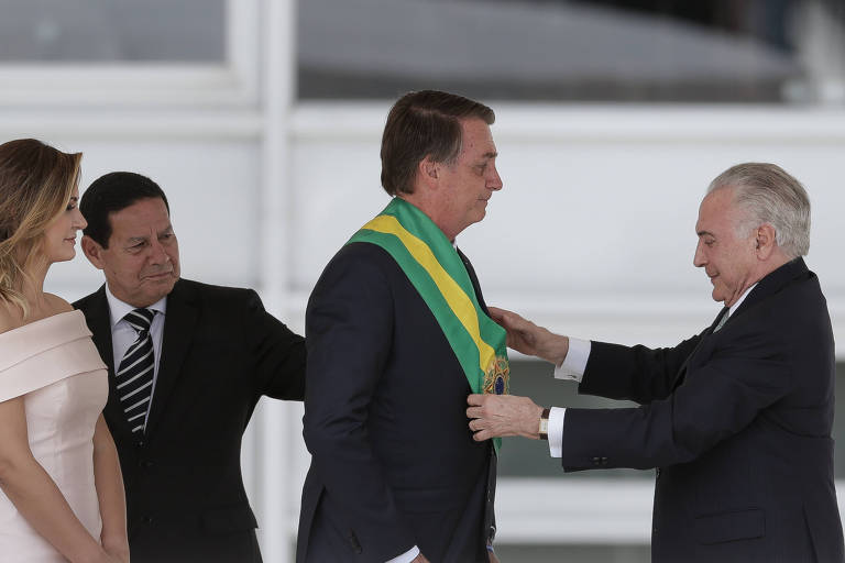 Jair Bolsonaro (PL) recebe a faixa presidencial das mãos do presidente Michel Temer (MDB), no parlatório do Palácio do Planalto, em Brasília