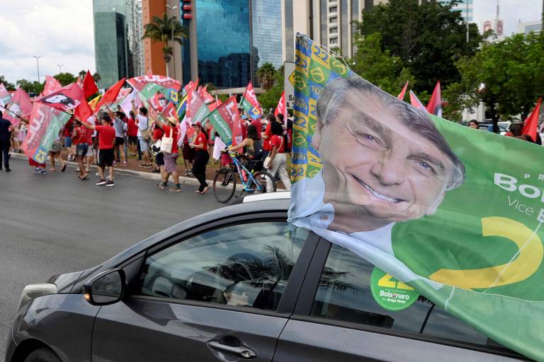 Apoiadores de Jair Bolsonaro passam por militantes petistas em rua de Brasília (DF)