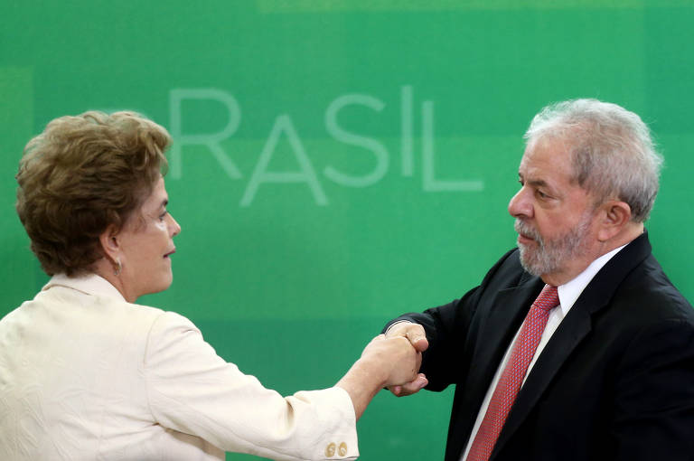 O ex-presidente Luiz Inácio Lula da Silva (PT) cumprimenta a então presidente Dilma Rousseff (PT) em sua nomeação como ministro da Casa Civil, cujo objetivo era negociar com a base que desembarcava em meio ao processo de impeachment de Dilma