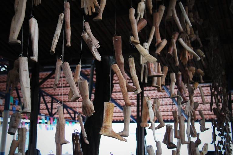 pedaços de pernas e mãos feitos madeira pendurados em telhado