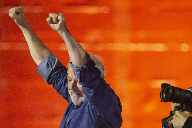Vestindo uma camisa azul, com os dois braços erguidos e os punhos fechados, Lula festeja na avenida Paulista, em São Paulo, a vitória sobre Jair Bolsonaro na eleição à Presidência da República