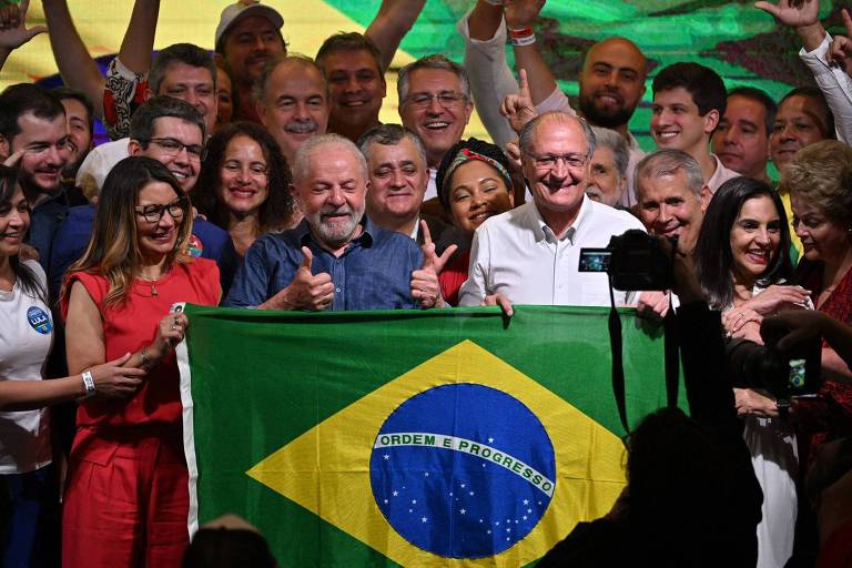 Lula e Alckmin tiram foto em frente a uma bandeira do Brasil
