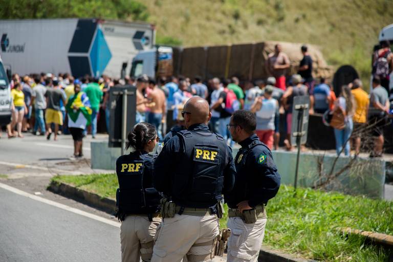 Policiais rodoviários federais observam movimento de caminhoneiros em bloqueio na rodovia Presidente Dutra, na região de Barra Mansa (RJ)