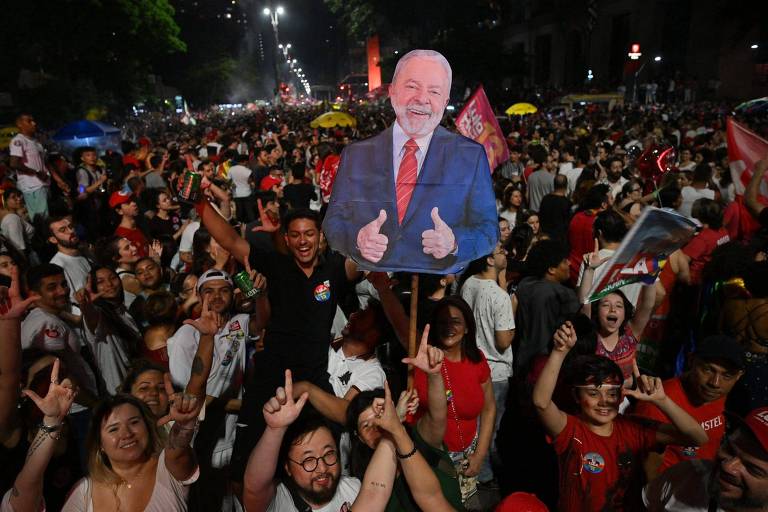 Multidão faz o "L" com as mãos e segura um cartaz de papelão do Lula