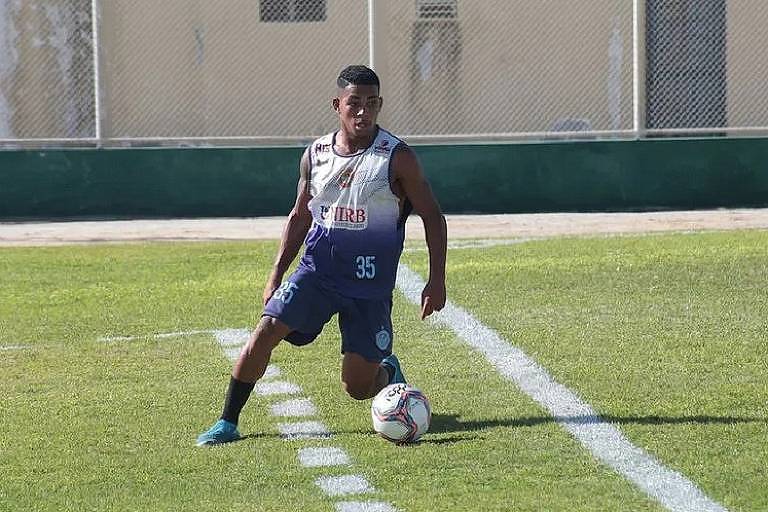 Homem negro joga futebol em campo e veste uiforme da Juazeirense