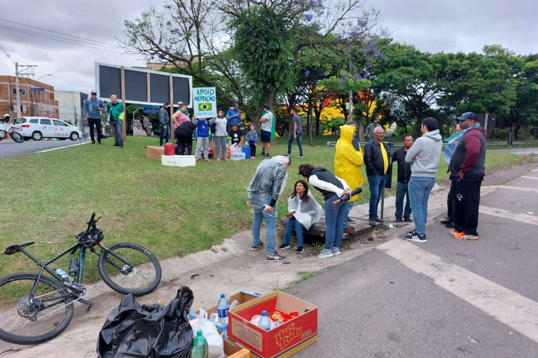 Pessoas distribuem água, marmita e suco a manifestantes bolsonaristas na rodovia Castelo Branco, na altura de Barueri