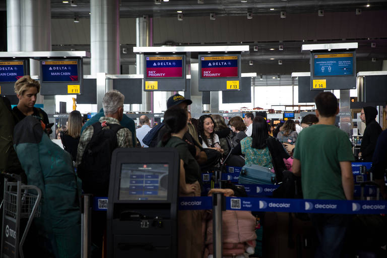 pessoas em fila cheia de aeroporto carregam bagagens 