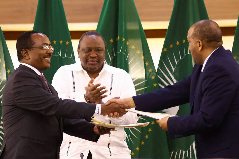 O ex-presidente queniano Uhuru Kenyatta aplaude o representante do governo etíope, Redwan Hussien, à esq., e o delegado de Tigré, Getachew Reda, após ambos assinarem, em Pretória, um acordo de cessar-fogo 