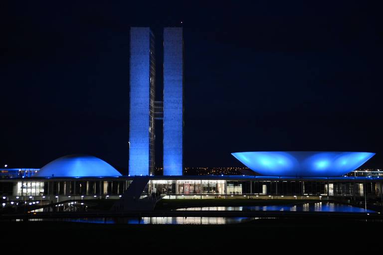 Imagem mostra fachada do Congresso Nacional, em Brasília, iluminada de azul à noite