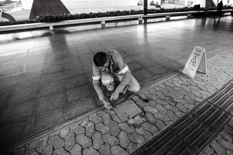 Funcionário passa cabos de energia embaixo da marquise do prédio, que recebeu três transições