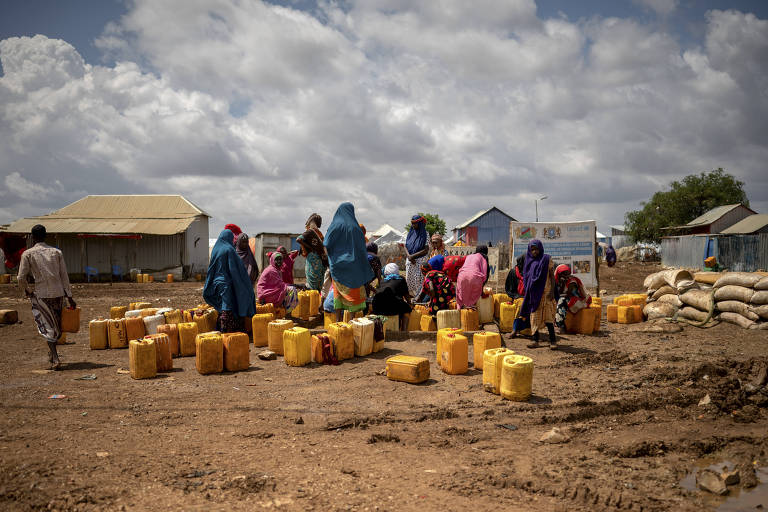 Somalis em campo para deslocados internos aguardam a retirada de água de poço em Baidoa.