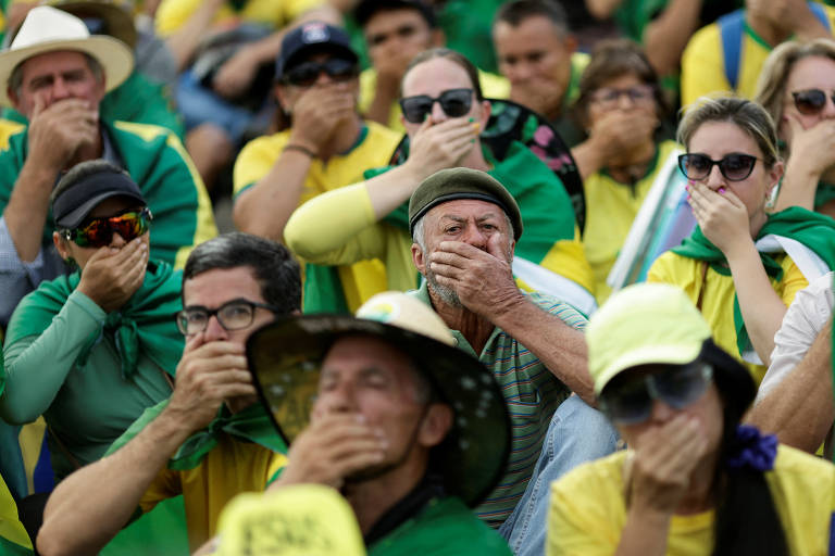 Apoiadores do presidente Jair Bolsonaro tapam a boca com a mão em protesto