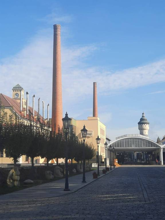 Fábrica da Pilsner Urquell, com chaminés e a antiga caixa d'água ao fundo, em Plzen, na República Tcheca