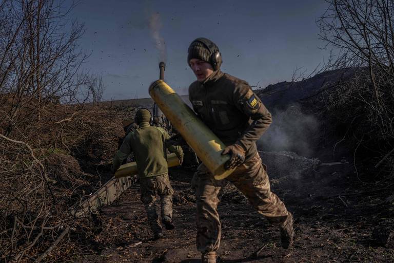 Soldado ucraniano carrega cápsula de projétil nos arredores de Bakhmut, no leste da Ucrânia