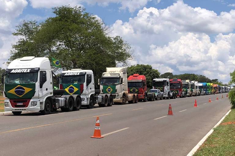 Caminhões de diferentes empresas aparecem enfileirados em uma rua ao lado do quartel-general do Exército, em Brasília, em 7/11/2022. Em alguns deles, é possível ler a palavra Agritex