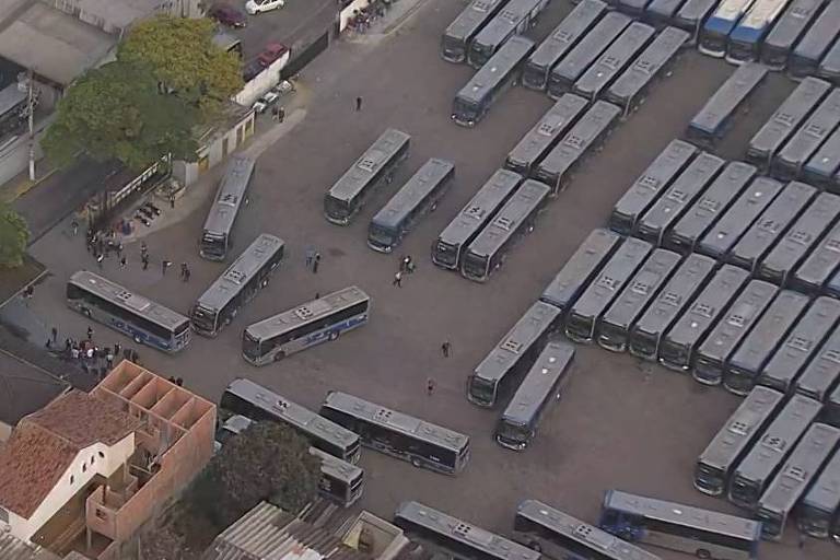 A imagem colorida mostra uma fila de ônibus vista do alto
