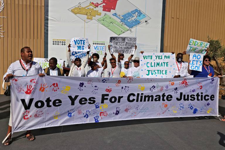 Membros da organização Estudantes das Ilhas do Pacífico que Lutam Contra as Mudanças Climáticas pedem em faixa para os delegados das nações votarem a favor da justiça climática na COP27