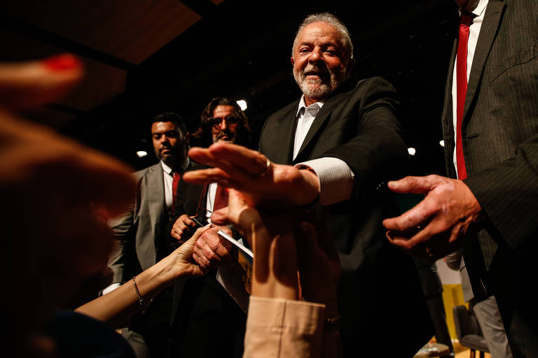 Imagem mostra Lula apertando as mãos de apoiadores