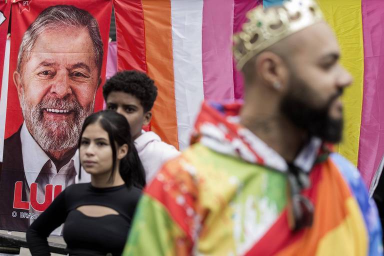 Ativistas LGBTQIA+ diante de toalha com a cara de Lula