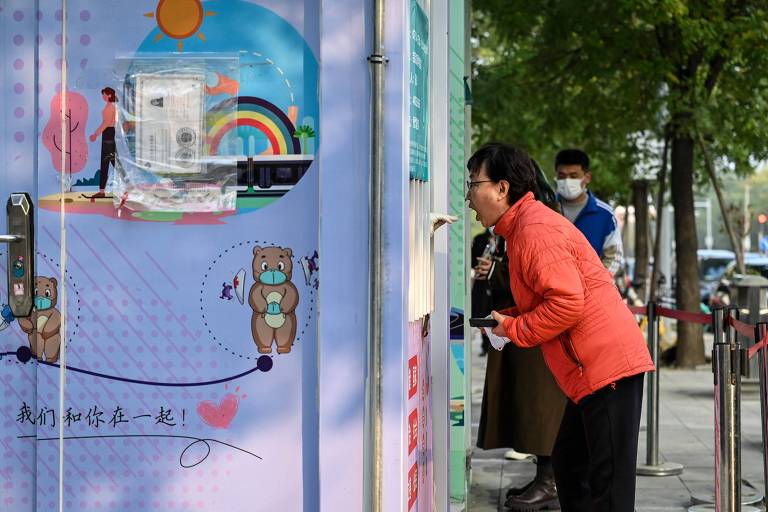 Mulher faz teste de Covid-19 em uma rua de Pequim
