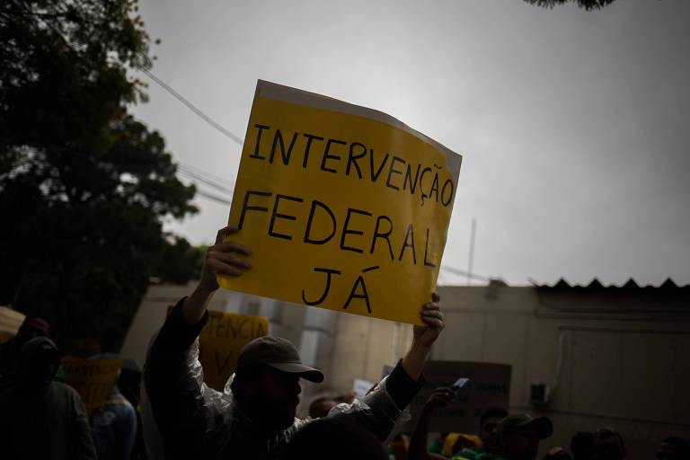 Homem segura cartaz em que está escrito "intervenção federal já"