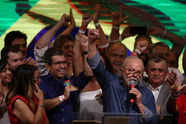 Imagemn mostra Lula em palco cercado por apoiadores durante discurso de vitória