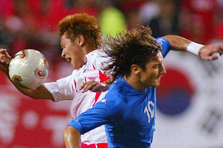 O sul-coreano Kim Nam-Il disputa bola com o italiano Francesco Totti na Copa do Mundo de 2002