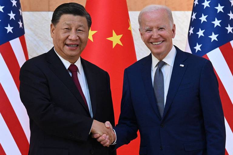 À esquerda, Xi aperta mão de Biden; atrás dos políticos, bandeiras da China e dos EUA
