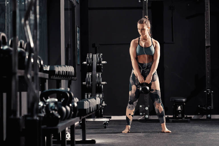 Mulher faz treinamento em academia 