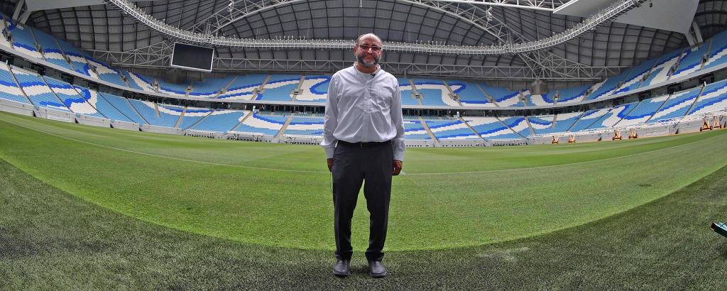 Saud Abdul Ghani, o Doutor Refresco, posa no estádio Al Janoubi, um dos que abrigarão jogos na Copa do Mundo do Qatar; o estádio está vazio