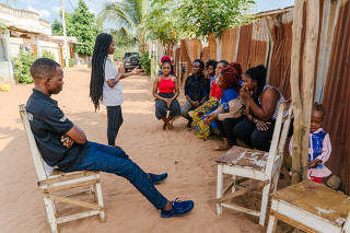 Aubierge Glora Attinganme, standing, a member of a local youth association that promotes family planning, speaks to a group of young women in Abomey-Calavi, Benin July 19, 2022. (Carmen Abd Ali/The New York Times)
