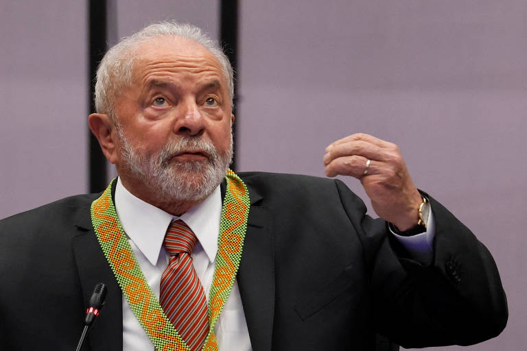 Lula gesticula enquanto discursa usando um colar indígena