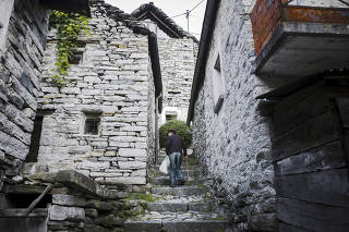 A man makes his way back home after buying bread from Eros Mella, in Corippo, Switzerland.
