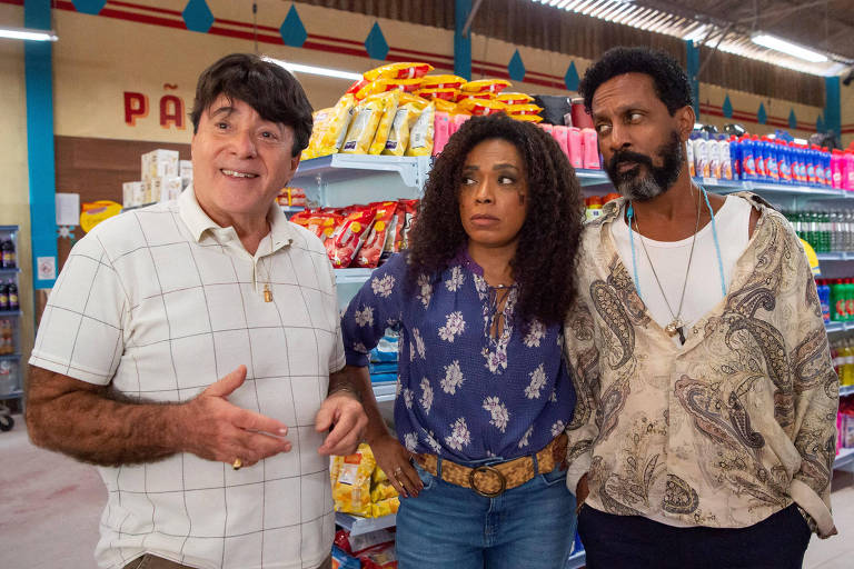 Em foto colorida, um trio aparece dentro de um supermercado