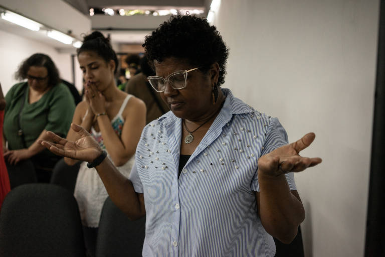 Mulheres oram em culto evangélico da Nossa Igreja Brasileira, no Rio de Janeiro