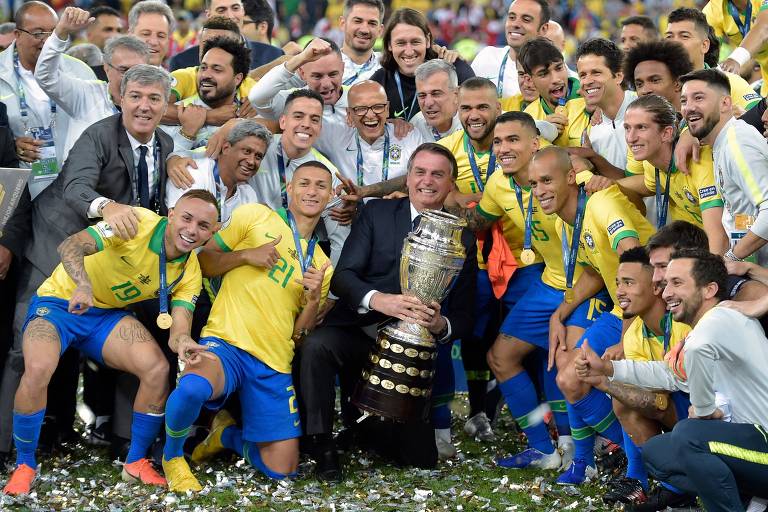 Jogadores posam com Bolsonaro, que segura o troféu