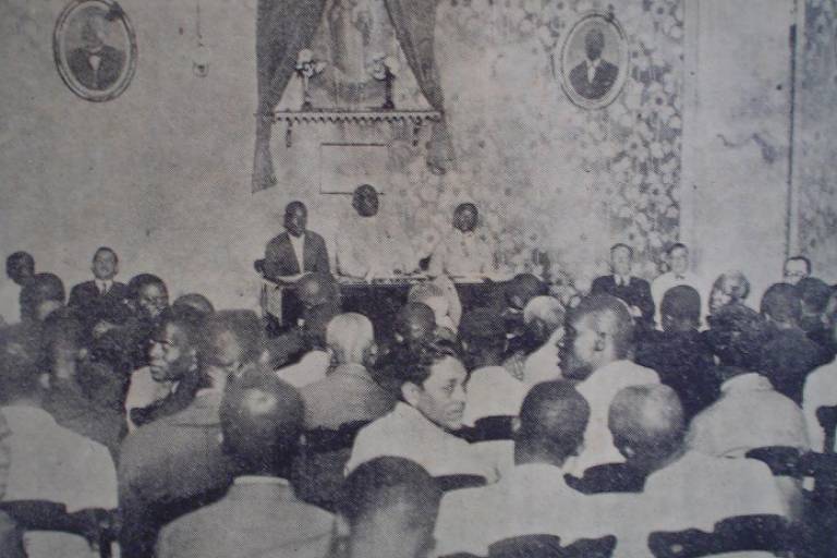 Foto em preto e branco mostra homens negros reunidos no salão nobre da SPD