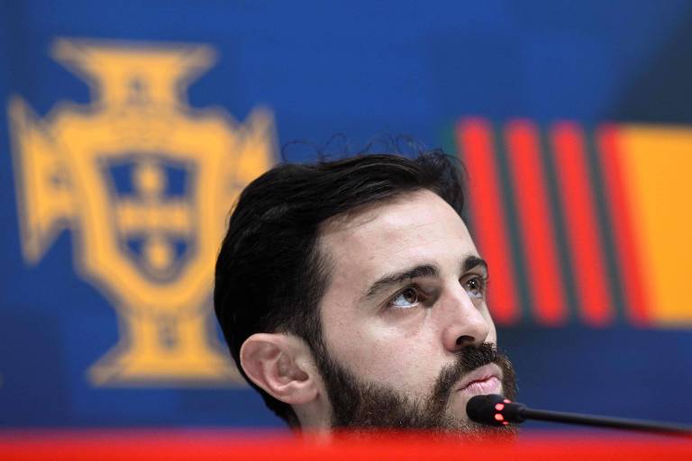 O meia Bernardo Silva, da seleção de Portugal, olha para a frente diante do microfone em entrevista no Qatar