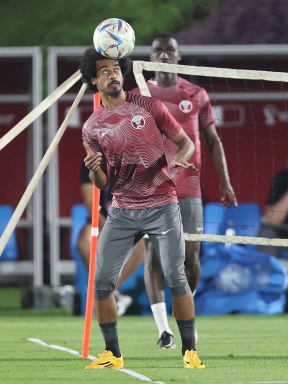 O atacante Akram Afif, uma das esperanças de gols para o anfitrião Qatar no Mundial deste ano, controla a bola com a cabeça em treinamento da equipe em Doha