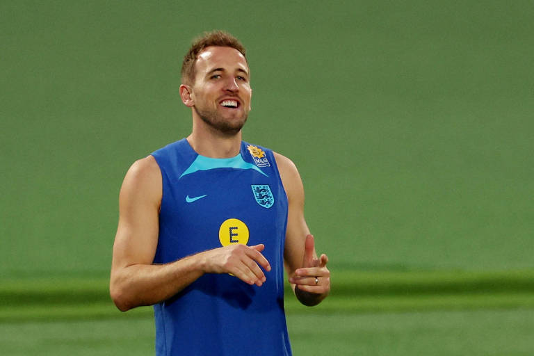 Usando camiseta azul sem mangas, Harry Kane sorri em treino da seleção da Inglaterra em Al Wakrah, no Qatar