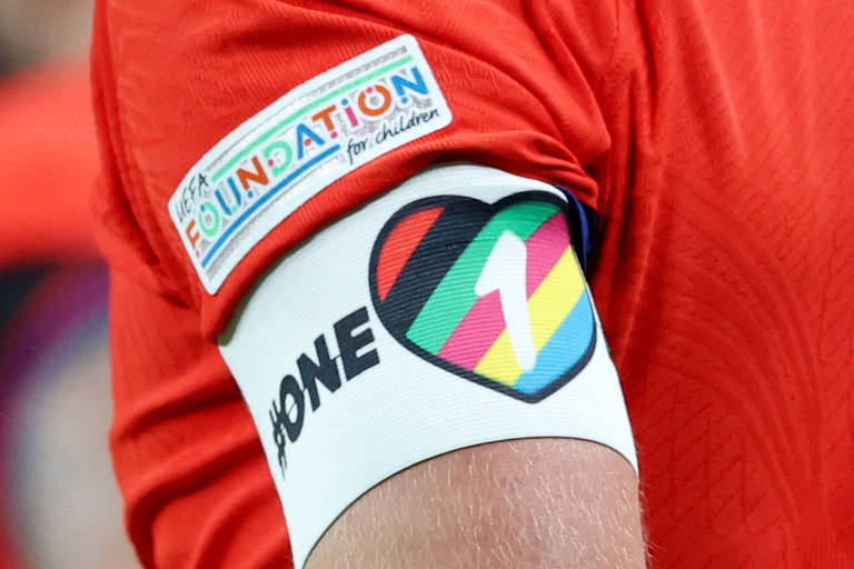 Braçadeira branca usada pelo jogador inglês Harry Kane traz a inscrição "One" ao lado de um coração com as cores do arco-íris com o número um dentro dele