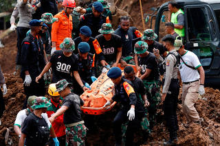 Indonesia rescue members carry a victims body from the site of a landslide caused by the earthquake in Cugenang,