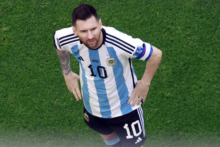 Messi olha para a frente com as duas mãos segurando a cintura