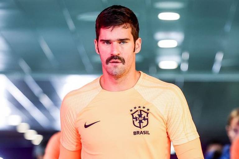 Em foto colorida, homem com camisa da seleção brasileira caminha em direção ao fotógrafo