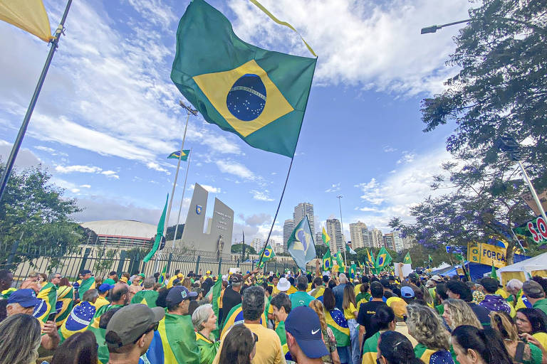 Apoiadores do presidente Bolsonaro vestem verde-e-amarelo e agitam bandeira do Brasil em meio a manifestação durante jogo do Brasil 