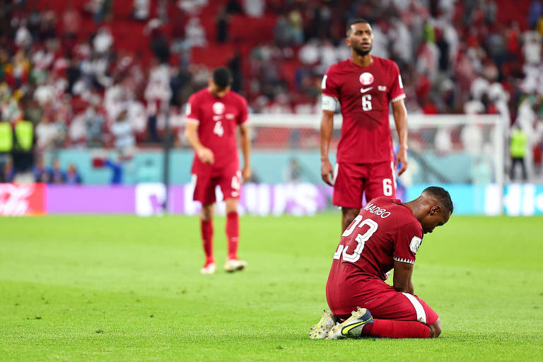 Jogadores do Qatar lamentam derrota contra Senegal no estádio Al Thumama, em Doha
