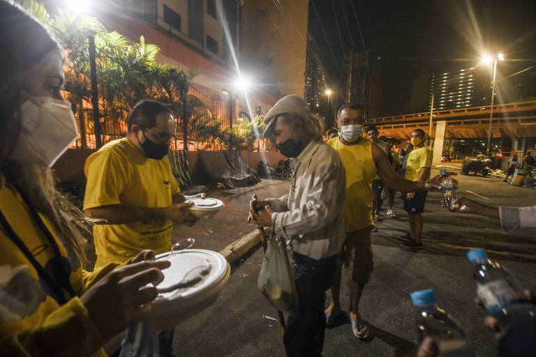 Moradores de rua assistidos pelo projeto Anjos das Ruas, que doa refeições na região central de SP
