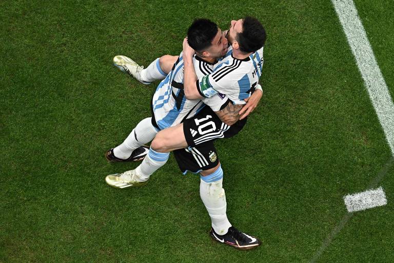 imagem de cima mostra os jogadores Enzo Fernandez (esquerda) e Lionel Messi comemorando abraçados o segundo gol da seleção argentina contra o México no campo